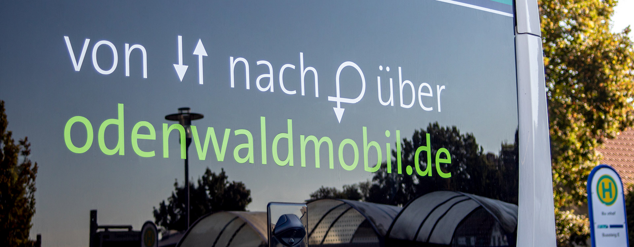 Hessenticket Die Heckscheibe eines Busses mit dem Schriftzug "von, nach, über - odenwaldmobil.de"